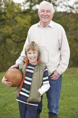 7182076-grandfather-with-grandson-holding-football-outside.jpg