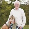 7182076-grandfather-with-grandson-holding-football-outside.jpg